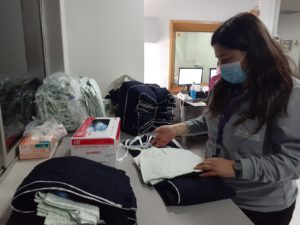 Macarena, trabajadora del programa ConFuturo de Fundación ConTrabajo, ordena ropa de trabajo de la clínica San Joaquín de UC Christus.